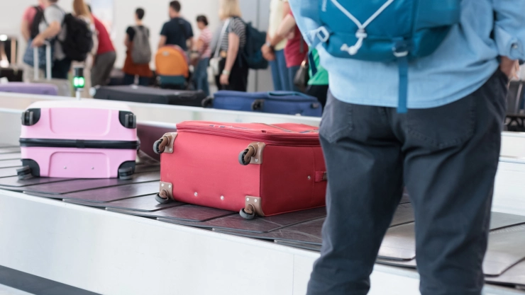 un usuario esperando su maleta en un aeropuerto.
