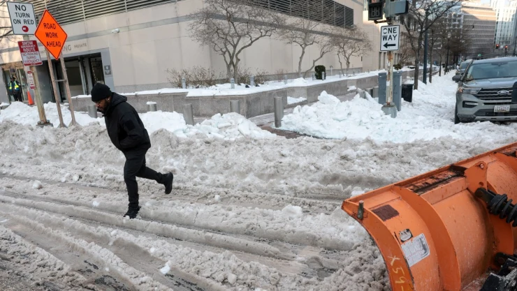 Un hombre camina a través de los montículos de nieve y hielo dejados por las quitanieves mientras la gente sigue lidiando con las consecuencias de una gran tormenta invernal que arrojó nieve y hielo en una gran franja de los Estados Unidos, en Washington, DC, EE. UU., el 28 de enero de 2026.