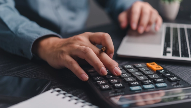 Una persona hace cuentas con una calculadora.
