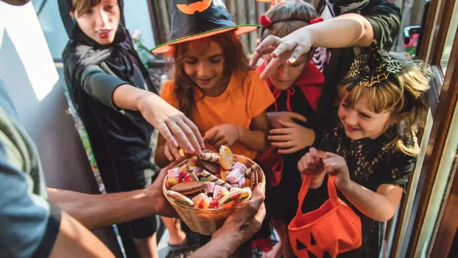 niños felices reciben caramelos en Halloween