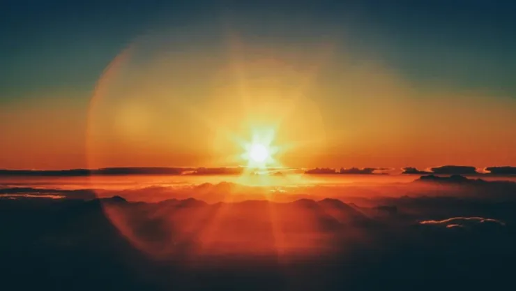La puesta de sol sobresaliendo sobre el horizonte.