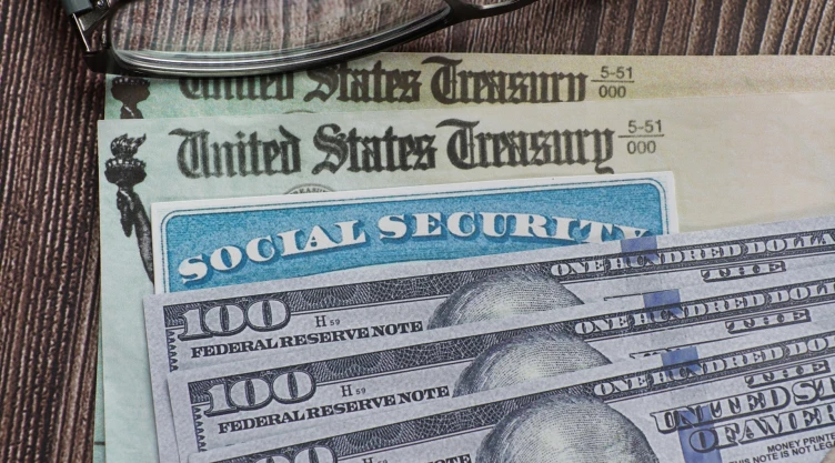 Un cheque del Seguro Social junto a dólares