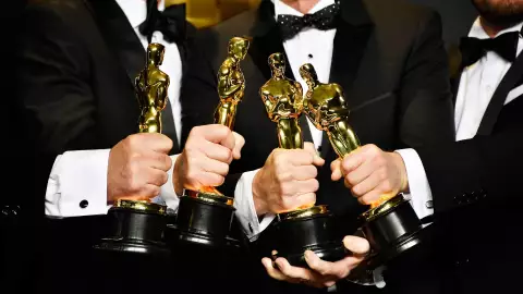 ganadores del Oscar sosteniendo la estatuilla en sus manos