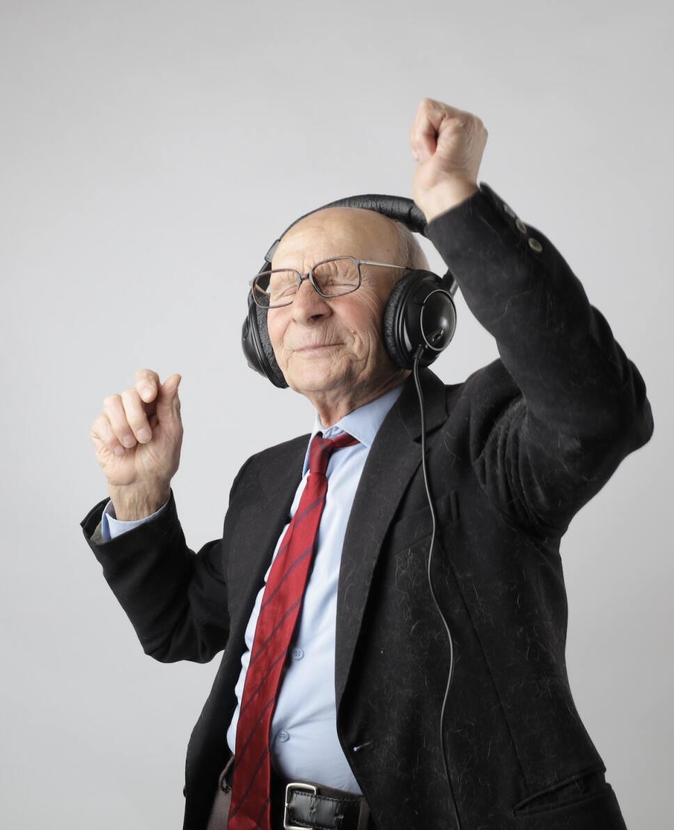 anciano bailando con audifonos y traje