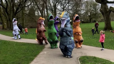 Un grupo de mamás disfrazadas de dinosaurios.jpg