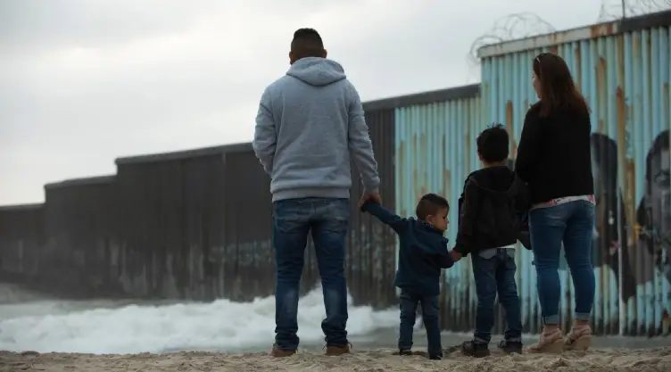 Una familia frente la frontera de México y Estados Unidos
