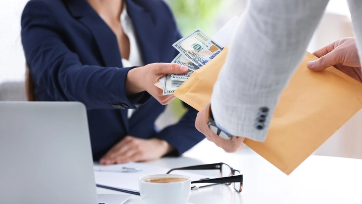 Empleada recibe su salario de parte de su jefe