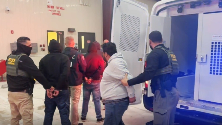 Agentes del ICE escoltan a los inmigrantes detenidos