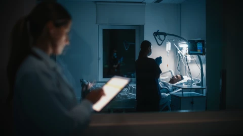 Profesional de salud con un paciente en un hospital.