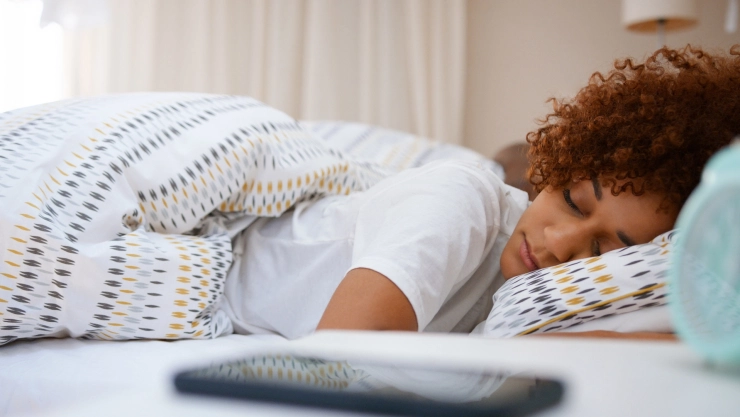 Una persona duerme en una cama.