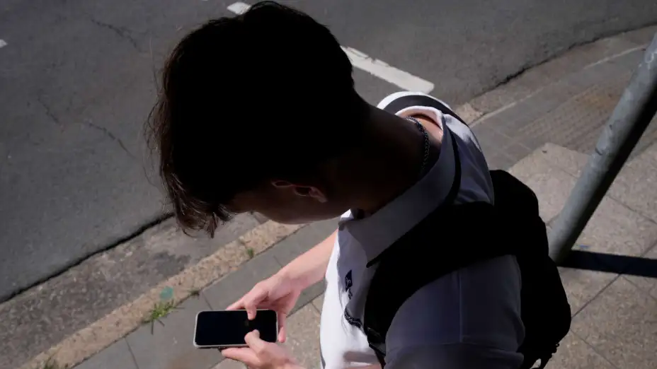 Un adolescente mira su teléfono en Sydney, Australia