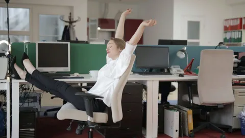 Persona estirando los brazos, tomando un descanso durante su jornada de trabajo