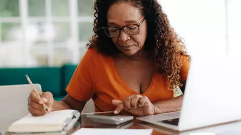 una mujer anciana hace c&aacute;lculos con su registradora