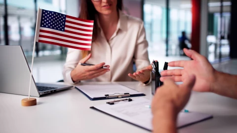 Una funcionaria estadounidense entrevista a un inmigrante.