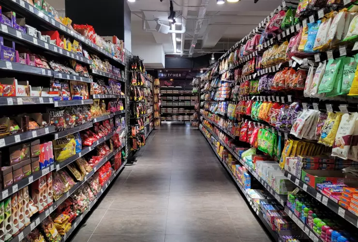Un pasillo de supermercado con productos en las góndolas.