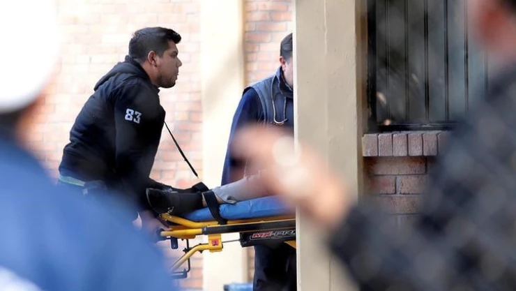Paramédicos llevan a una persona en una camilla después de un tiroteo en una escuela privada en Torreón, México.