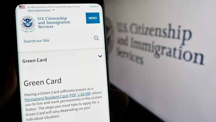 Una imagen de un teléfono en el que se ve la página del USCIS.