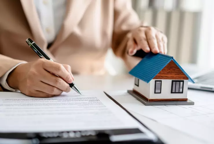 Una persona firma la hipoteca de una casa.