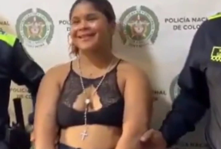 Mujer detenida con armas posa y sonríe para la foto.png