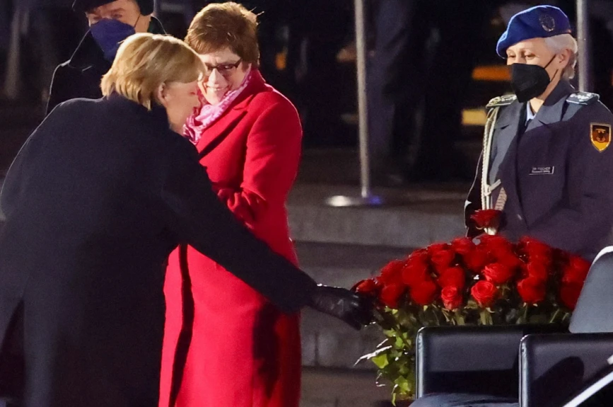 Angela Merkel elige una rosa roja de la ceremonia de despedida.