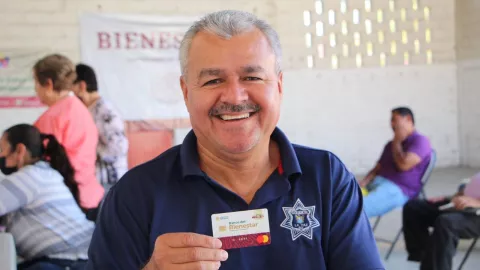 hombre sostiene su Tarjeta del Bienestar