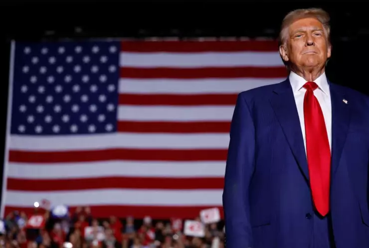 El presidente electo Donald Trump frente a una bandera estadounidense.