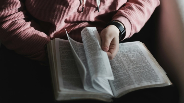Mujer hojeando biblia.
