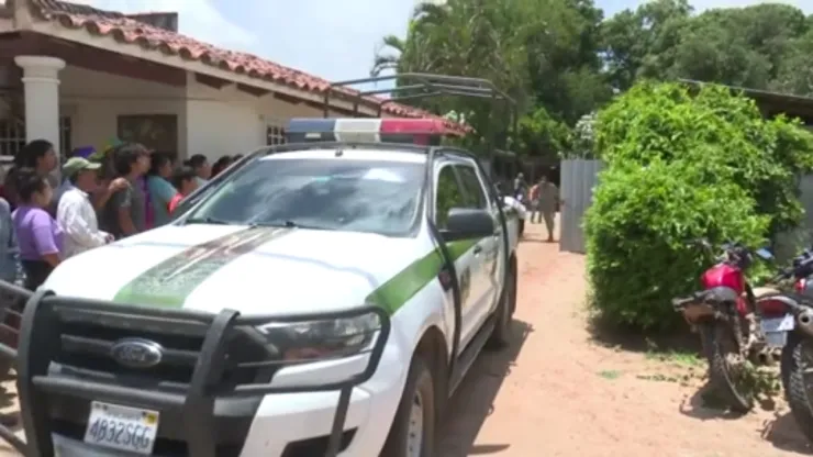 vecinos y una patrulla de la policía de Bolivia afuera de la casa donde ocurrió el crimen
