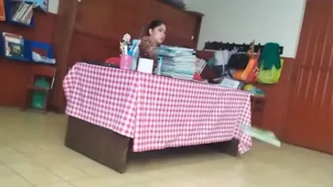 Maestra avienta cuadernos