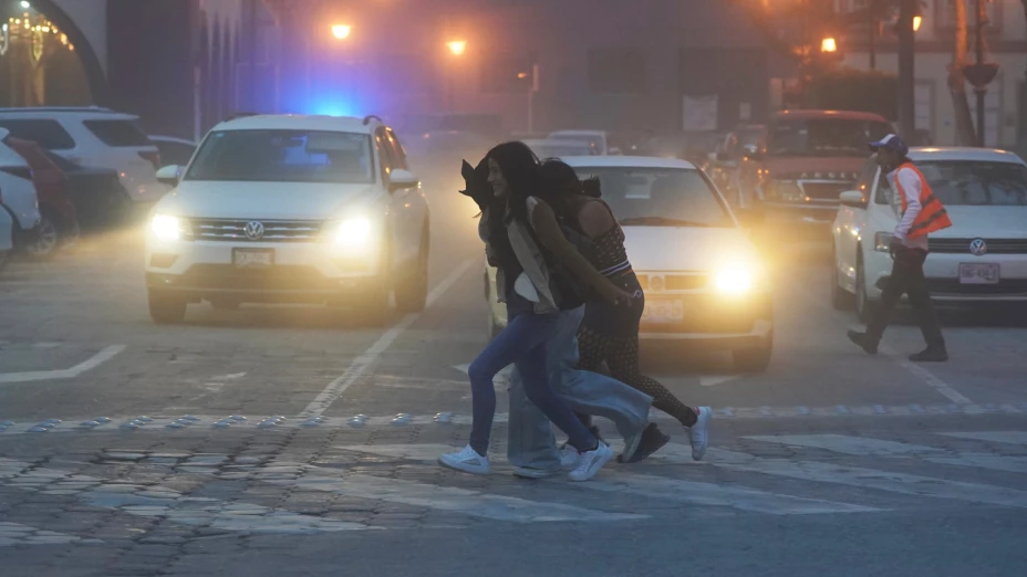 Mujeres caminan por las calles cubiertas de ceniza del volcán Popocatépetl en Atlixco, México.