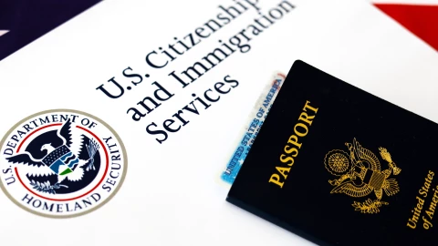 Boletín del USCIS junto a pasaporte estadounidense