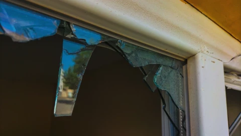 Una puerta de vidrio de una casa rota.