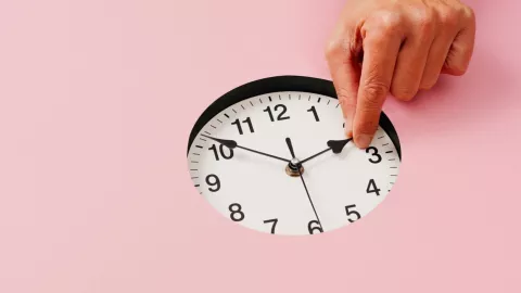 Una persona modifica la hora en un reloj.