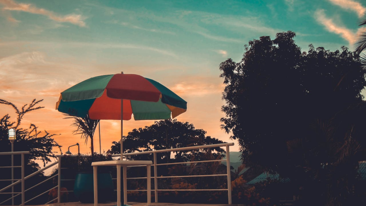 ¿Vacaciones? El atardecer se refleja con un paraguas de colores y árboles al rededor para hacer referencia al primer puente de 2025.