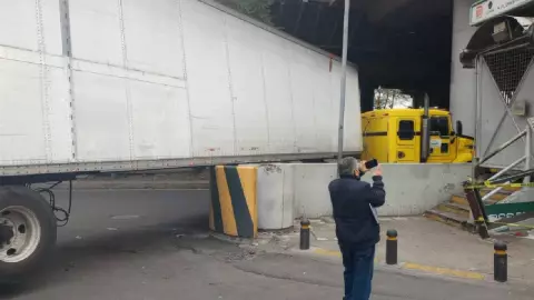 Tráiler se atora en la entrada del Metro Ricardo Flores Magón tras mala maniobra.