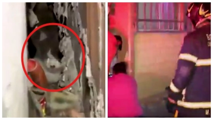 Mientras Dormía: Gato huye de perro y queda atrapado entre bardas; rescate demora horas sin éxito. En la imagen se observa al gato atrapado mientras los bomberos y vecinos hacen hasta lo imposible por rescatarlo.