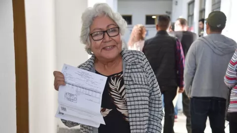 Mujer adulta mayor mostrando el pago de su impuesto predial en Ahome