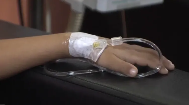 Mano de menor recibiendo medicamentos contra el cáncer.