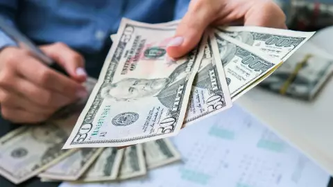 Una mujer empresaria entrega dólares