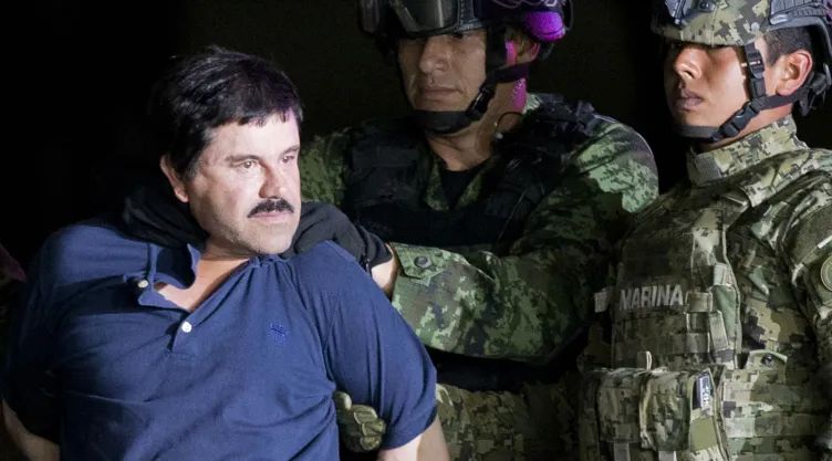 Esta foto de archivo del 8 de enero del 2016 muestra a Joaquín “El Chapo” Guzmán esposado durante una presentación ante la prensa, mientras soldados del ejército y la infantería de Marina de México lo llevan a un hangar federal en la Ciudad de