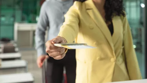 Una persona entrega sus documentos al personal del aeropuerto.