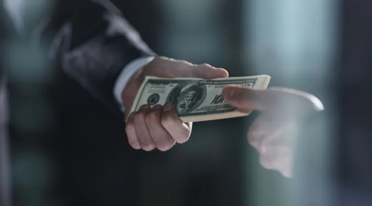 Una persona entrega dinero a otra persona.