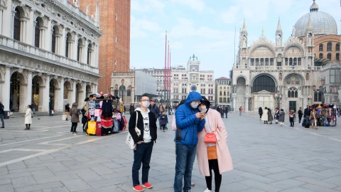 Tourists wear protective masks in Saint Mark’s Square in Venice after two coronavirus cases have been confirmed in Italy