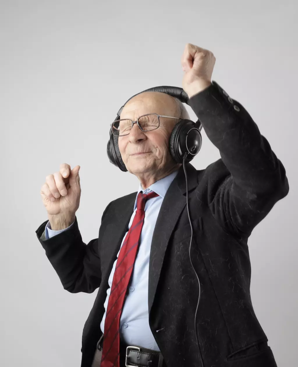 anciano bailando con audifonos y traje