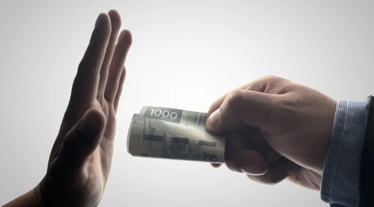 Foto de persona dando dinero a otra.