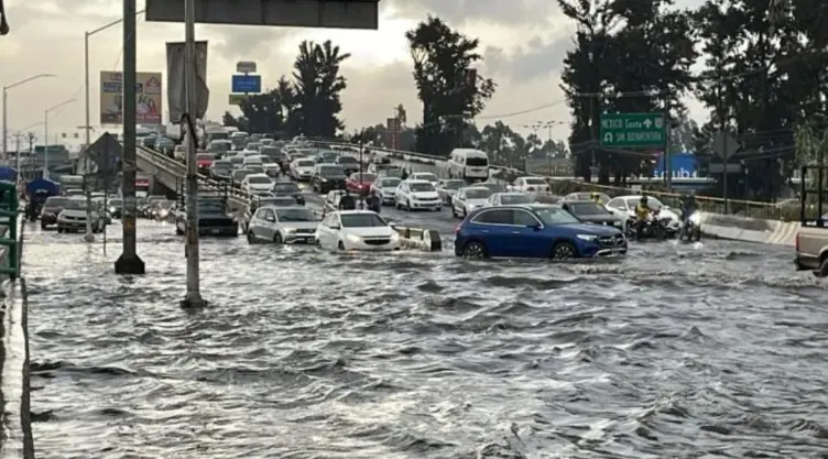 Inundaciones en la CDMX, coches se orillan para evitar pasar sobre un espejo de agua.