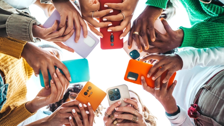 Un círculo formado por personas que sostienen teléfonos en sus manos