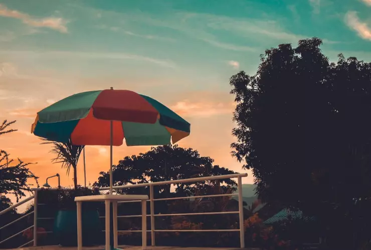 ¿Vacaciones? El atardecer se refleja con un paraguas de colores y árboles al rededor para hacer referencia al primer puente de 2025.