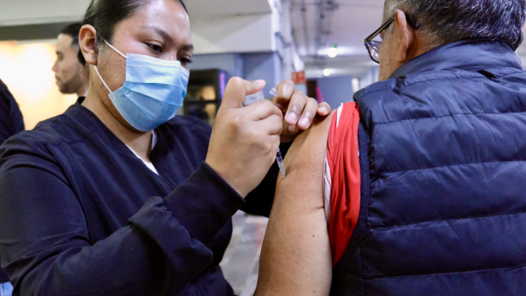 Enfermera de la secretaría de salud de Jalisco vacunando a un hombre contra el sarampión