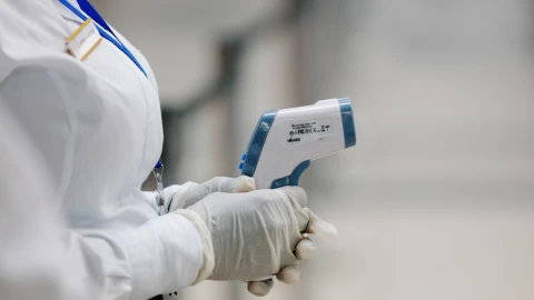 A health worker holds a thermometer as she waits to screen travellers for signs of the coronavirus at the Kotoka International Airport in Accra